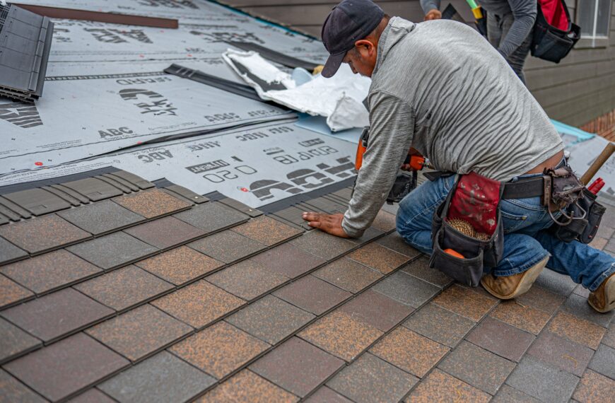 Skilled roofer installing asphalt shingles, ensuring quality home renovation.